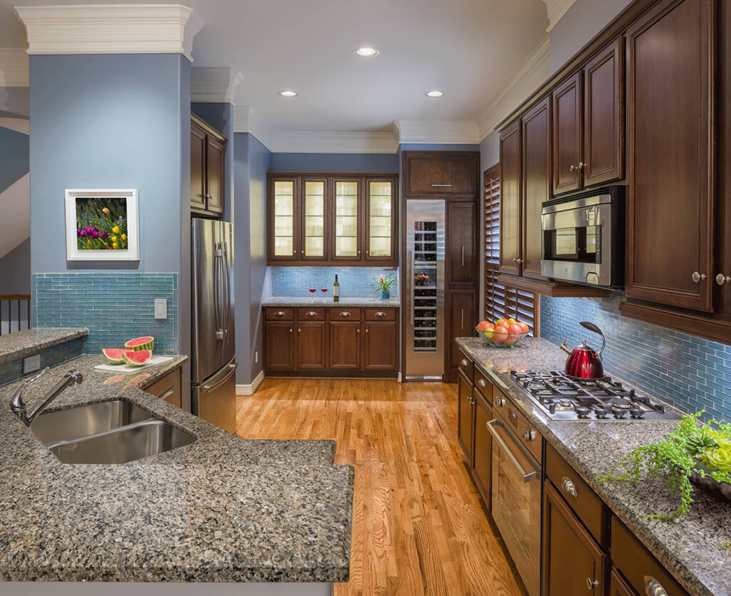 A kitchen with blue cabinets and granite counter tops.