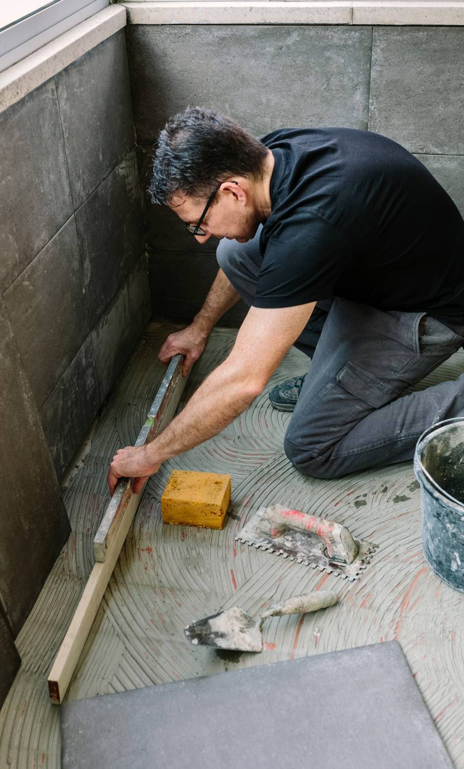 a man is working on a floor with a hammer
